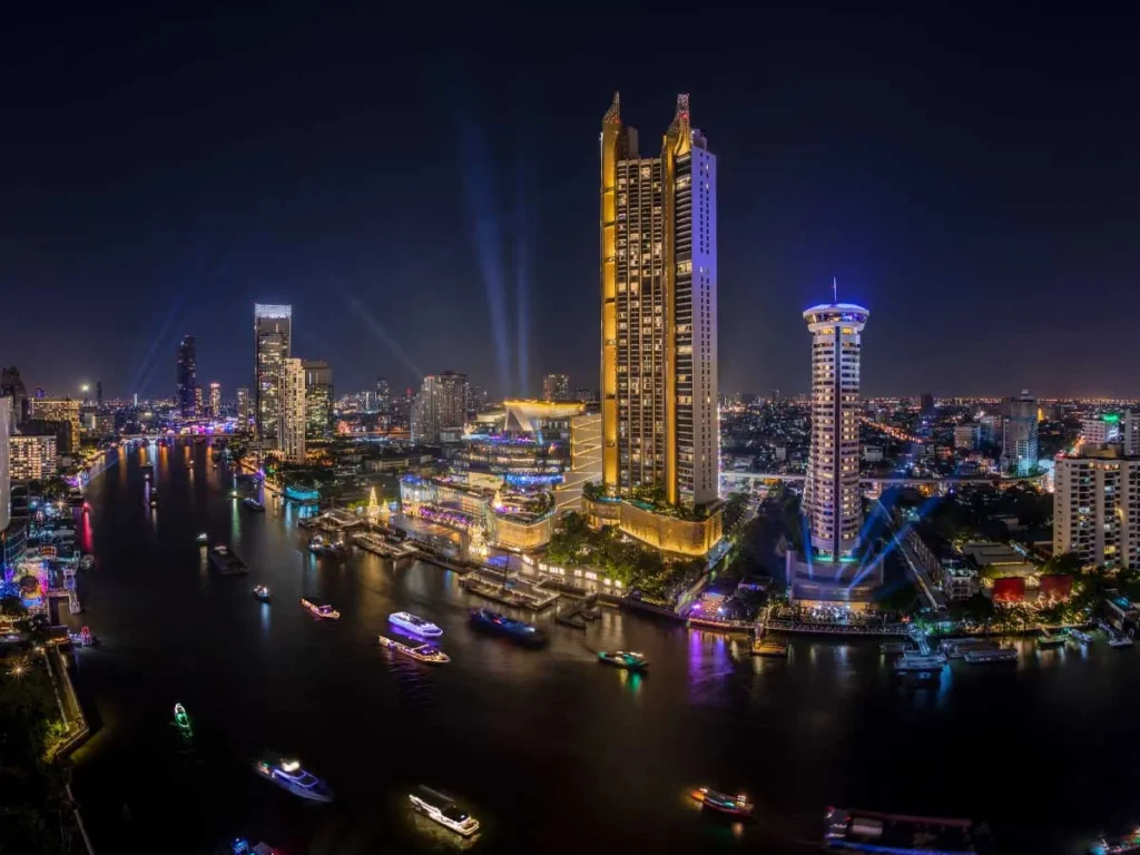 bangkok skyline at night along the chao phraya river with city lights and boats