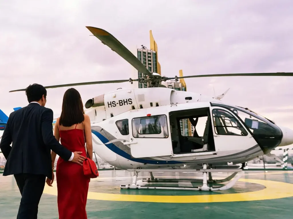 couple boarding a private helicopter on a bangkok rooftop helipad