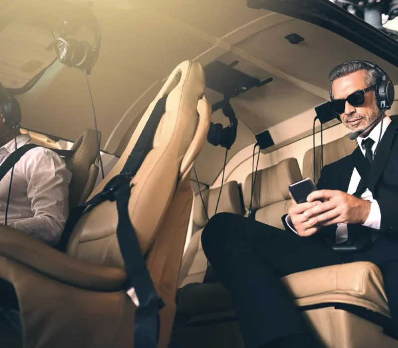 mature businessman using a mobile phone while traveling in a helicopter
