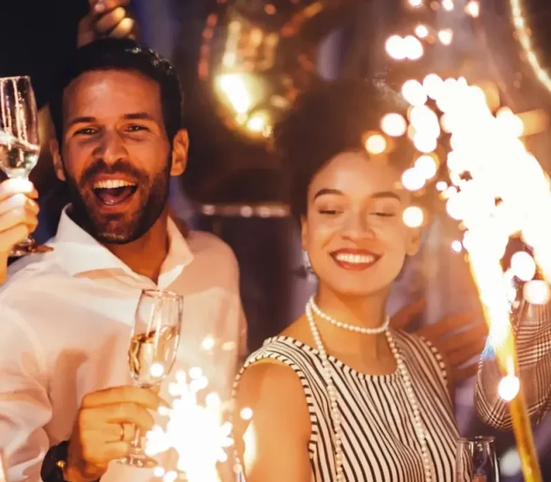 People celebrating with glasses of champagne and sparklers