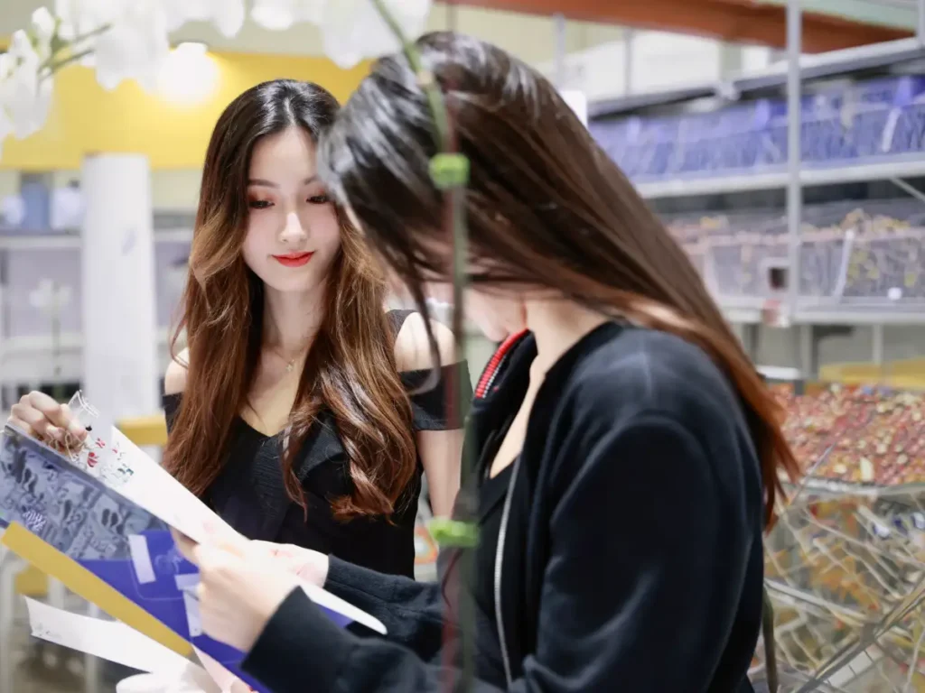 event hostesses reviewing booking details for a bangkok exhibition