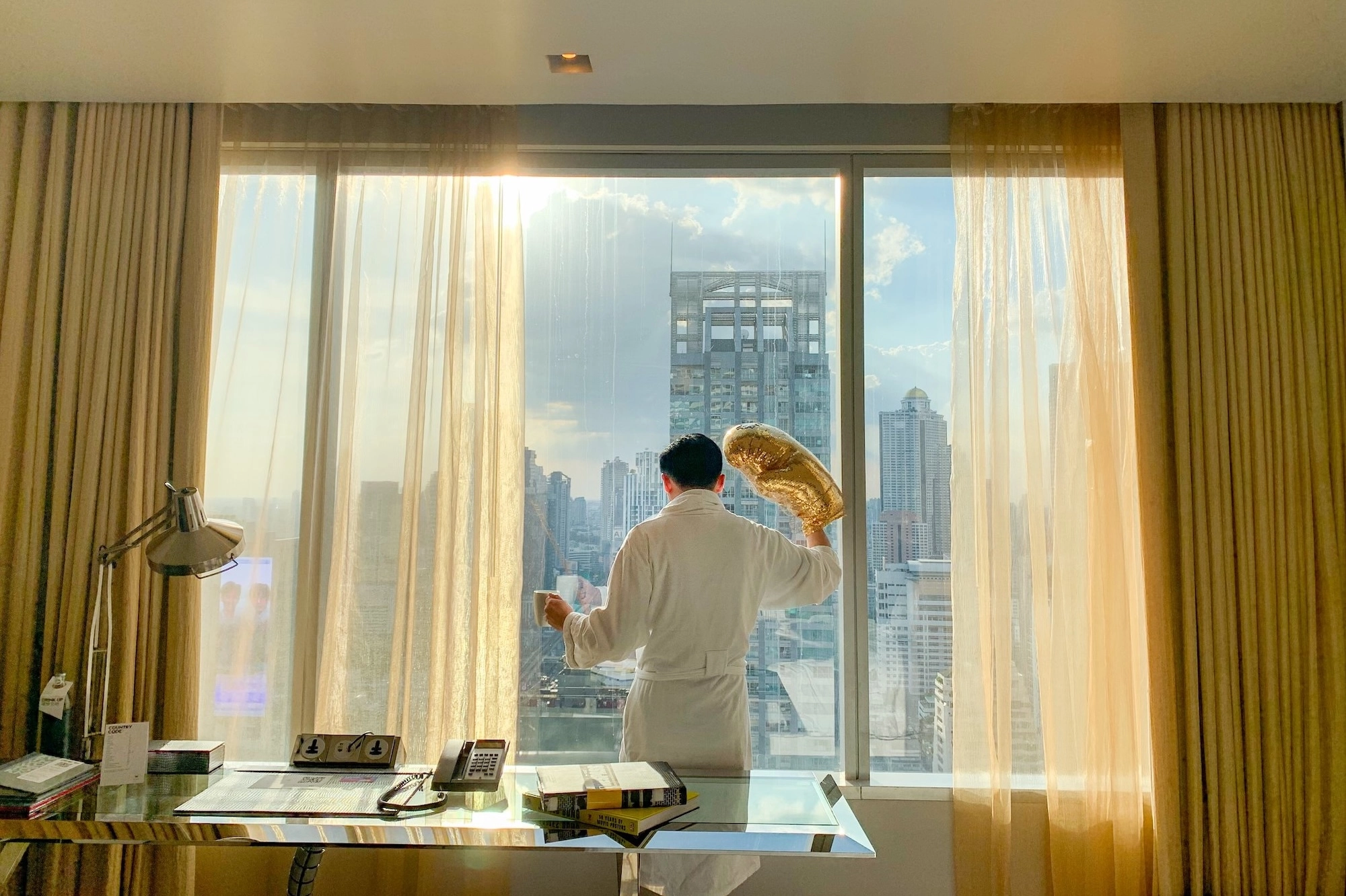 guy wearing a golden glove and a bathrobe in a hotel room in Bangkok