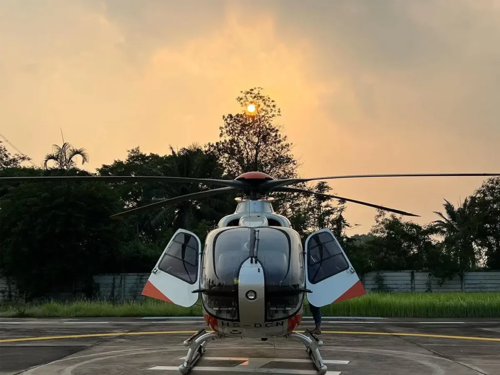 helicopter with doors open at sunset before an evening transfer