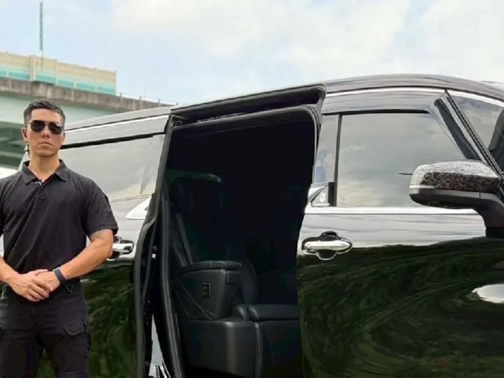 private security officer positioned beside executive van for client pickup