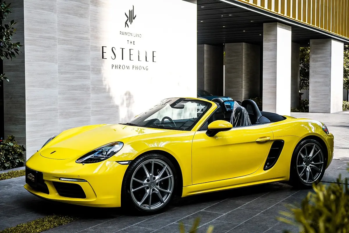 Yellow Porsche Boxster 718 parked in front of The Estelle Phrom Phong